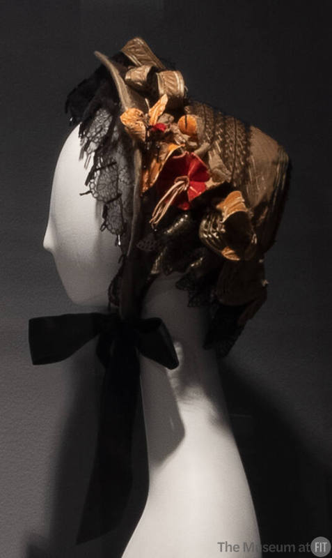 Tan velvet bonnet with black lace and pink velvet flowers and leaves throughout