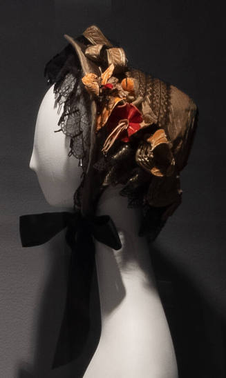 Tan velvet bonnet with black lace and pink velvet flowers and leaves throughout