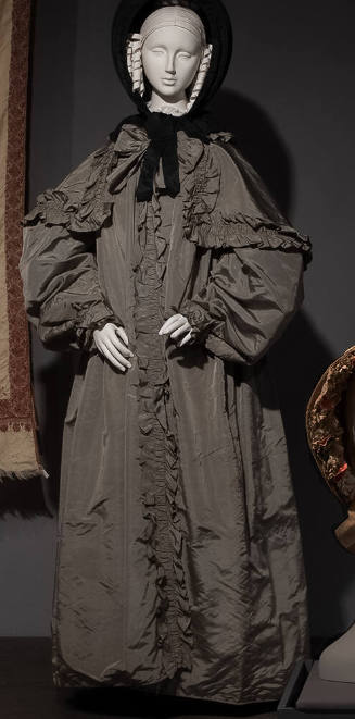 Grey silk taffeta floor length coat with voluminous sleeves, bow at neck and self-ruffle down c…