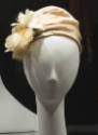 Beige turban hat with white fabric flower at front