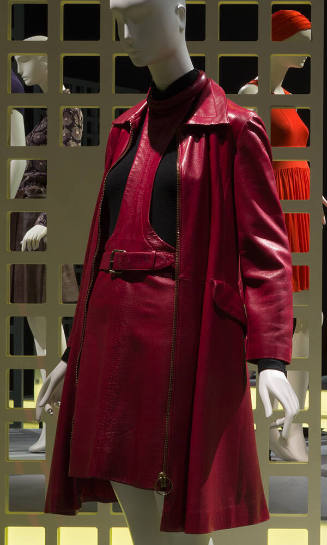 Red leather coat over matching belted halter neck jumper dress over black turtleneck sweater 