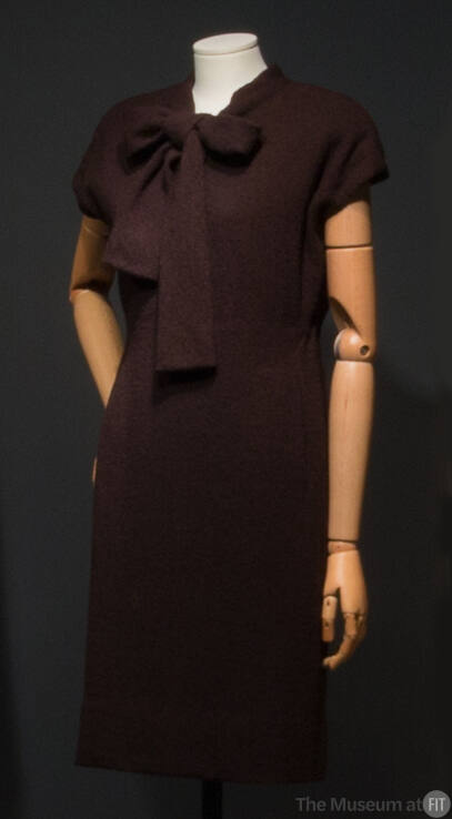 Dark brown sheath dress, cap sleeves, and large bow tie collar
