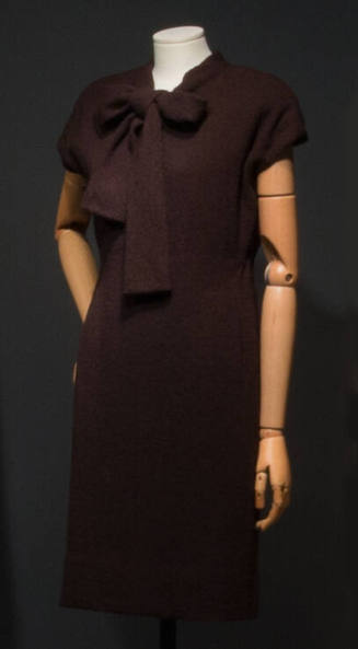 Dark brown sheath dress, cap sleeves, and large bow tie collar