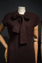 Dark brown sheath dress, cap sleeves, and large bow tie collar