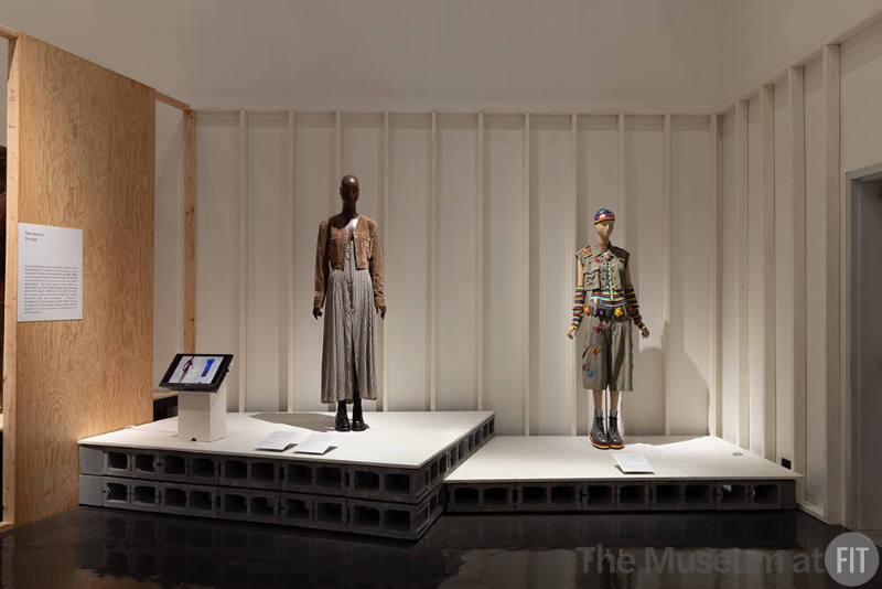 An overview of the section in Reinvention and Restlessness: Fashion in the Nineties highlighting Grunge, featuring designs by Marc Jacobs for Perry Ellis (left) and Anna Sui. 
