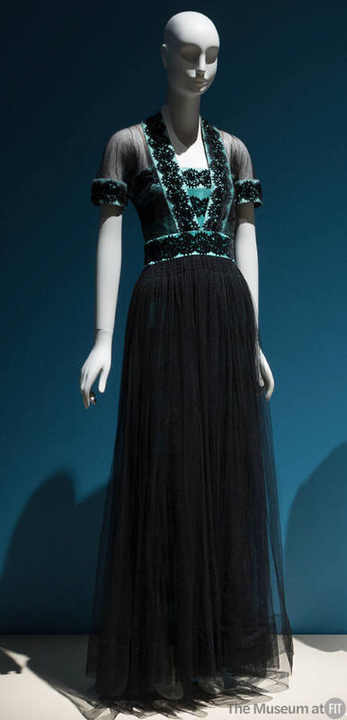 Short sleeve evening gown of black net and blue silk satin bodice with black circular pattern a…