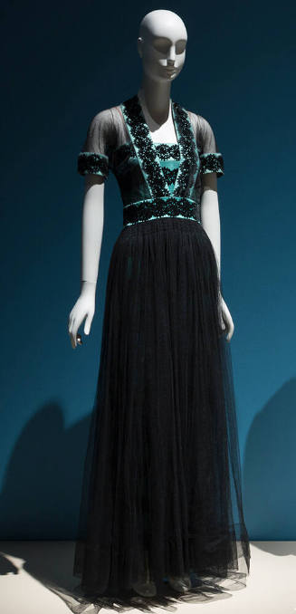 Short sleeve evening gown of black net and blue silk satin bodice with black circular pattern a…