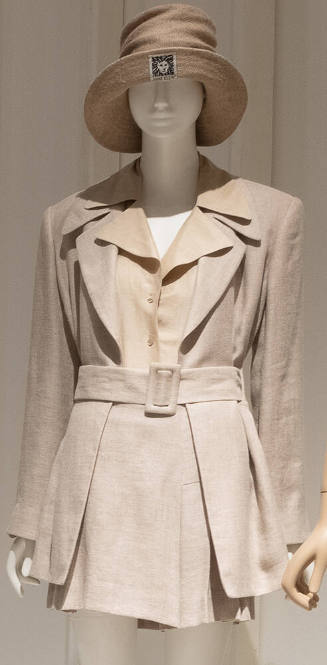 Beige belted jacket, pleated mini skirt, sheer blouse, with coordinating hat