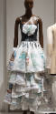 Full length dress with shoulder straps, bow on bust, and tiered overskirt made of small white b…