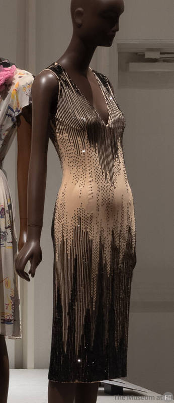 Beige sleeveless below knee length evening sheath dress with vertical black sequins concentrate…