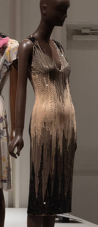 Beige sleeveless below knee length evening sheath dress with vertical black sequins concentrate…