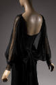 Back view of black silk dress with long sheer dolman sleeves with button cuffs