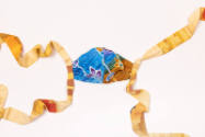 Flat view of blue floral design face mask with long dyed yellow side bow ties
