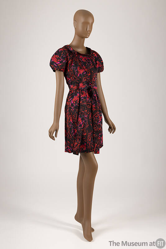 Red, pink and black abstract swirl printed dress with short sleeves, self belt and above the kn…