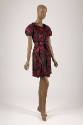 Red, pink and black abstract swirl printed dress with short sleeves, self belt and above the kn…