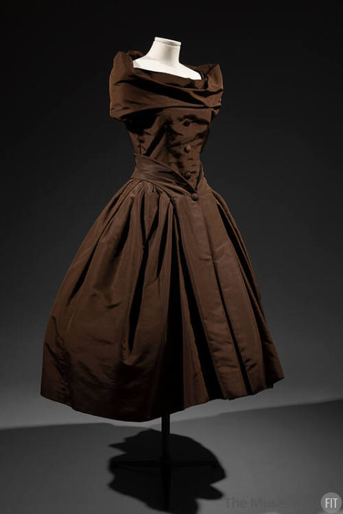 Sleeveless brown cocktail dress with off-the-shoulder cowl neck and calf length flared skirt