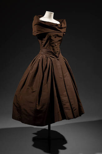 Sleeveless brown cocktail dress with off-the-shoulder cowl neck and calf length flared skirt