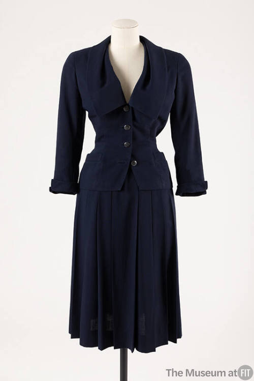 Navy blue suit of fitted button front jacket with wide Chelsea style collar and below calf leng…