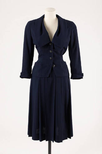 Navy blue suit of fitted button front jacket with wide Chelsea style collar and below calf leng…