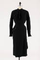 Black wool long sleeve top with asymmetric buttons at shoulder and neck tie, matching below-the…