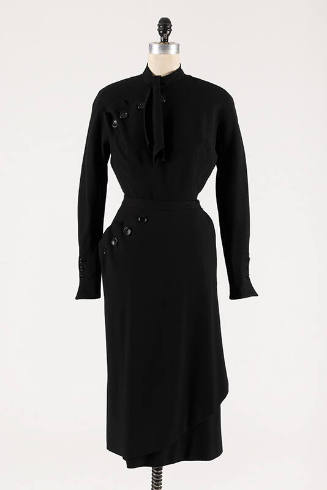 Black wool long sleeve top with asymmetric buttons at shoulder and neck tie, matching below-the…