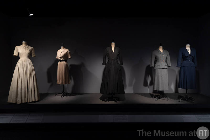 Dior + Balenciaga, Left to right 72.112.144 (striped cotton dress), 72.81.19 (beige dress), 74.135.8 (black dress), PL74.1.32 (gray suit), 2017.8.7 (blue wool suit)