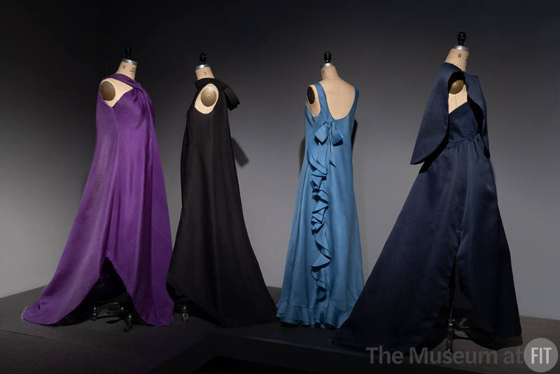 Dior + Balenciaga, Left to right 71.240.4 (purple evening dress), P85.89.1 (black evening dress), 91.183.16 (blue evening dress), 86.66.4 (blue evening dress and capelet)
