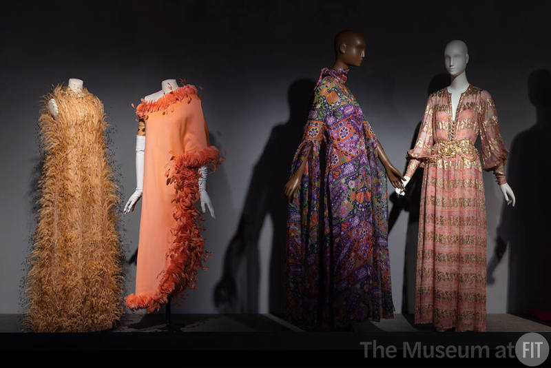 Dior + Balenciaga, Left to right 87.19.1 (ostrich feather dress), 89.160.2 (orange evening gown), 73.73.1 (multicolor evening dress and scarf), 80.58.5 (printed pink and gold metallic evening dress)