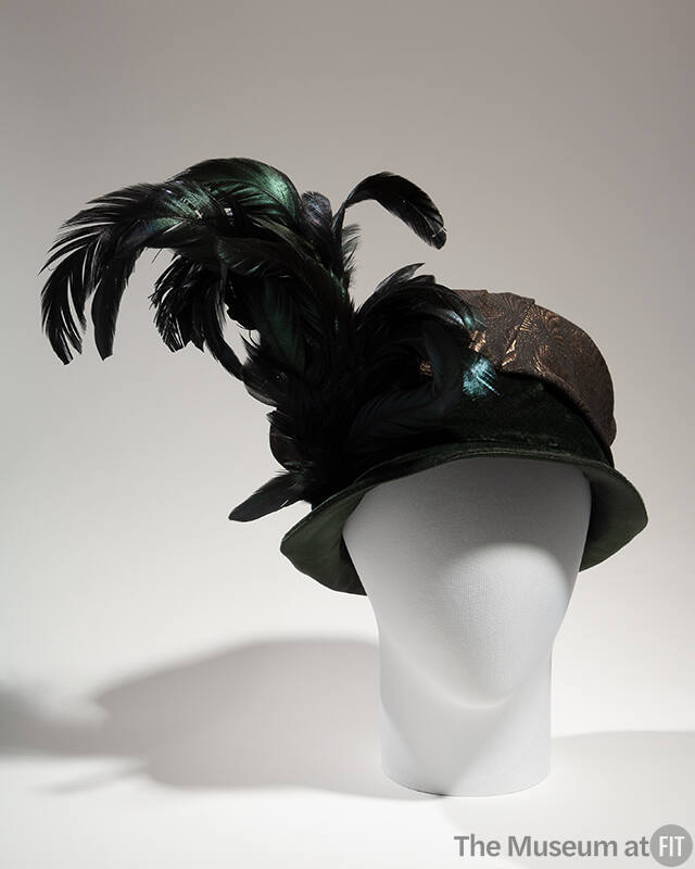 Black turban hat with shallow velvet brim, crown wrapped in brocade fabric and large black/gree…
