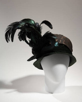 Black turban hat with shallow velvet brim, crown wrapped in brocade fabric and large black/gree…
