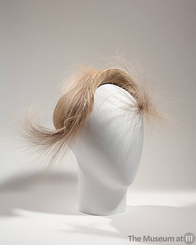Beige hat with short upturned brim and two large plumes of matching feathers forming front swir…