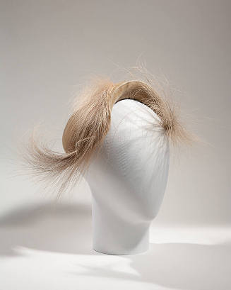 Beige hat with short upturned brim and two large plumes of matching feathers forming front swir…