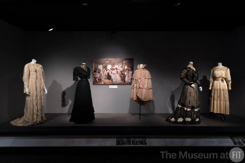 Designing Women_14 Left to right: Fernande Burel, Tea Gown, Paris, circa 1900 (2003.12.1); Jeanne Paquin, Afternoon dress, Paris, circa 1902 (72.66.6); Image by Henri Gervex, "Cinq Heures Chez Paquin" (Five Hours at the House of Paquin), 1906; Jeanne Paquin, Evening Cape, Paris, 1897 (P83.19.7); Callot Soeurs Evening dress, Paris, circa 1909 (P90.2.3) and Afternoon dress, Paris, summer 1917 (86.156.1)