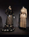 Designing Women exhibition installation view of two mannequins in a black floor length dress an…