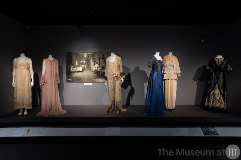 Designing Women_16 Left to Right: Attributed to Lucile, Two Peignoir and Slip ensembles, Possibly New York, circa 1918 (90.180.11, 90.180.9); Image of the Rose Room at the couture house of Lucile, New York, circa 1915; Attributed to Lucile, Tea Gown and Slip, Possibly New York, circa 1918 (90.180.4); Lucile, Lady Duff Gordon, Evening Dress, London, circa 1912 (81.131.12); Afternoon suit, New York, circa 1913 (P93.15.2); Madame Percy, Afternoon dress, London, circa 1910 (P83.20.3)