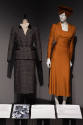 Designing Women exhibition installation view of two mannequins in a grey and black striped suit…