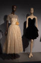 Designing Women exhibition installation view of two mannequins in a floor length gold metallic …