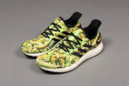 Pair of green and yellow plantain print sneaker with black laces, trim and white soles