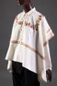 ¾ view of muslin button front poncho style top with red and brown embroidery