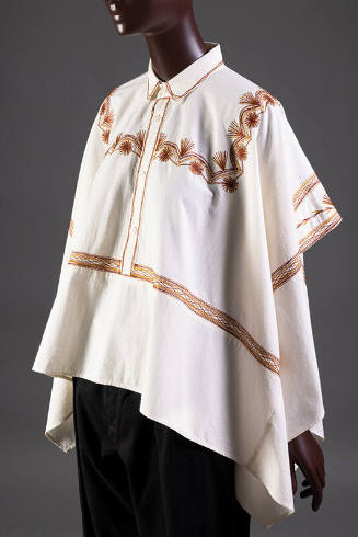 ¾ view of muslin button front poncho style top with red and brown embroidery
