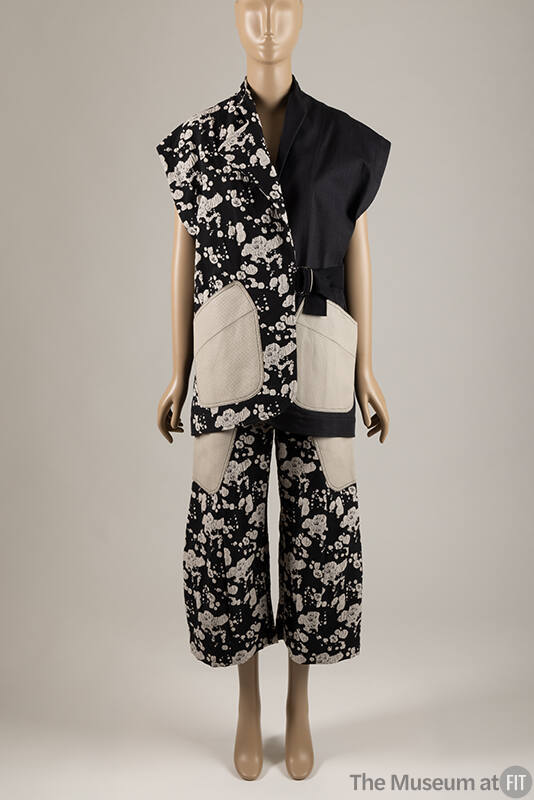 Black with off-white splatter print sleeveless collarless jacket with off-white patch pockets a…