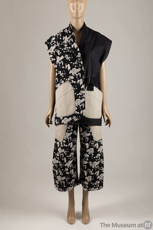 Black with off-white splatter print sleeveless collarless jacket with off-white patch pockets a…