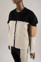 Detail ¾ view of black, off-white and tan colorblocked set showing black jacket zipper and whit…