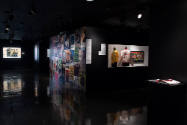 Hip Hop Style exhibition installation view of two jackets in a case, a wall of flyers and a lar…