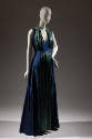Sleeveless floor-length blue and green evening dress with deep V-neck framed with a collar of s…