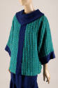 3/4 view of green & turquoise loose woven tunic top; dark blue collar, center stripe, and cuffs