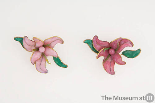 Pair of brooches in light and dark pink in the shape of orchids with green leaves outlined in g…