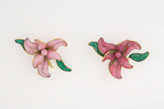 Pair of brooches in light and dark pink in the shape of orchids with green leaves outlined in g…