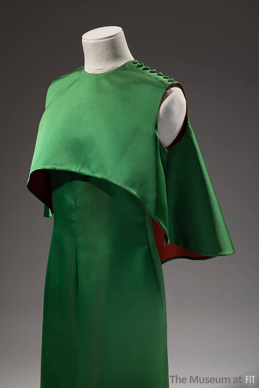 Sleeveless emerald green gown, double faced with red, with matching capelet
