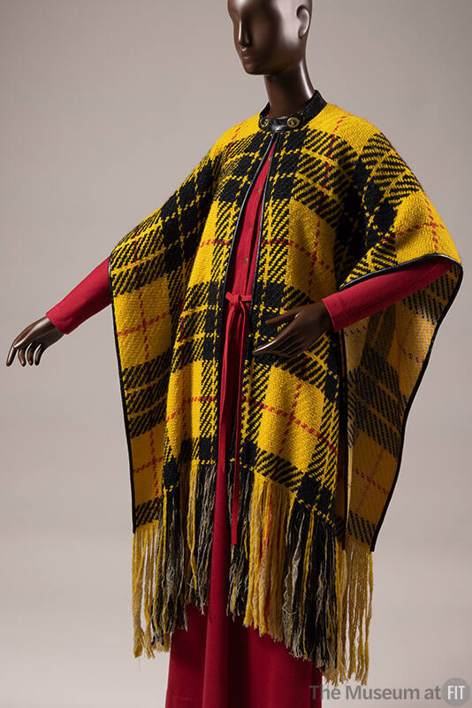 Yellow, black, and red plaid poncho with self fringe hem over long sleeve dark pink dress